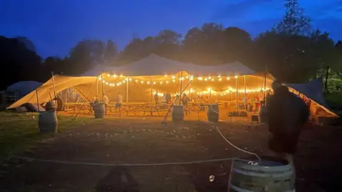 A tent, lit with lights, at The Field in Alness