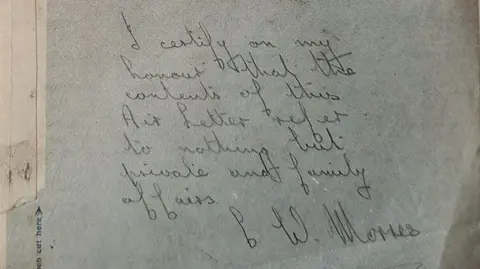 A piece of paper with handwritten black writing that says "I certify on my honour that the contents of this Air Letter refer to nothing but private and family affairs" and is signed C W Morris.