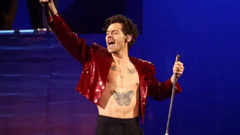 Reuters Harry Styles performs at the Brit Awards at the O2 Arena in London, he wears a red sequin jacket 