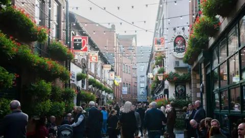 Getty Images People walking in the Cathedral Quarter area of Belfast in 2017