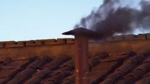 Black smoke emerges from the Sistine Chapel chimney