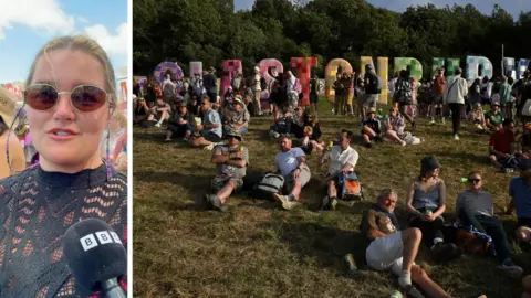 Woman wearing sunglasses on left side. Crowds gathered in front of Glastonbury sign