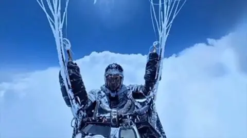 Chinese paraglider Peng Yujiang hangs above the clouds