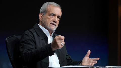 Masoud Pezeshkian gestures during a debate