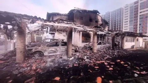 CBS Charred, burnt out cars in what looks to have been a car park