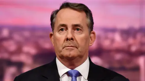 Liam Fox looking past the camera in a suit blue tie when he was Trade Secretary, during his appearance on BBC One current affairs programme The Andrew Marr Show