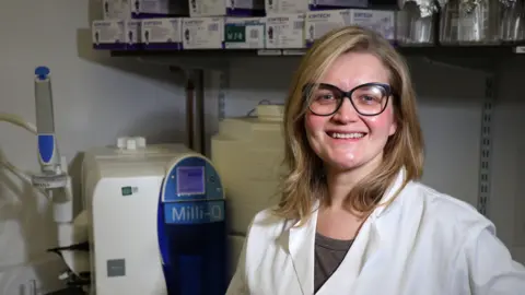 University of Aberdeen Professor Kate Britton of the University of Aberdeen's archaeology department, in a laboratory with its water purification equipment behind her.