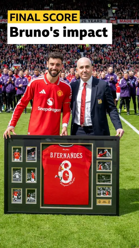 Bruno Fernandes is presented with a framed shirt to mark 20 assists in a Premier League season by CEO Omar Barrada