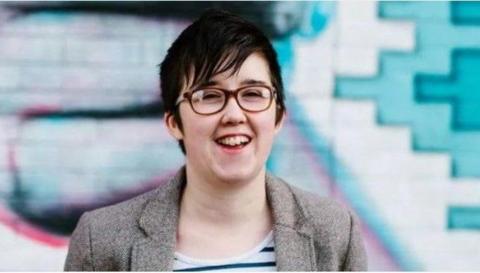 Lyra McKee smiling and wearing glasses and a tweed jacket