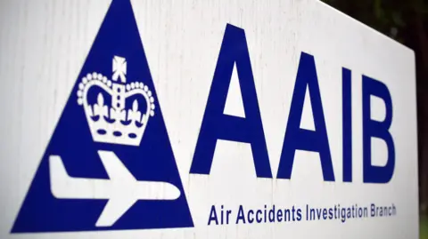CARL COURT/AFP/Getty Images A white logo with 'AAIB' in blue letters on top