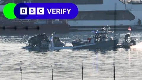 Rescue boat on river pulling up plane debris 