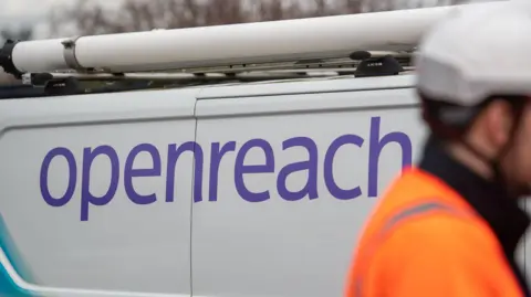 PA Image shows a parked Openreach van with a man wearing orange high vis and a white hard hat.
