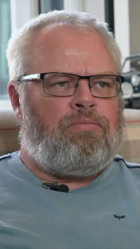 Close up middle-aged man with grey beard, glasses and receding white hair