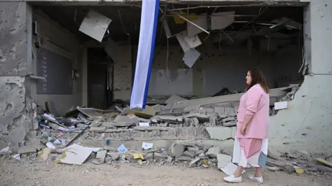 A municipality worker inspects a school damaged by ballistic missiles fired from Iran, in Gedera, Israel, 02 October 2024