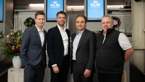 Stephen King, Chief Operations Officer, Ports of Jersey, Chris Van Erp - KLM Commercial Director UK&I, Jerome Salemi - KLM General Manager UK&I and Paul Holley, Head of Route Development, Ports of Jersey. They are all pictured standing wearing smart work clothes 