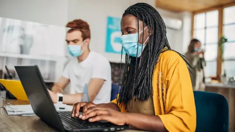 Employees wearing masks in an office