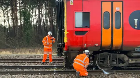 Andrew Sinclair/BBC Engineers beside train that derailed