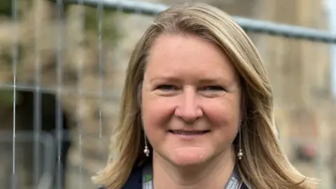 Sarah Clarke, project delivery manager, standing outside the castle, looking at the camera