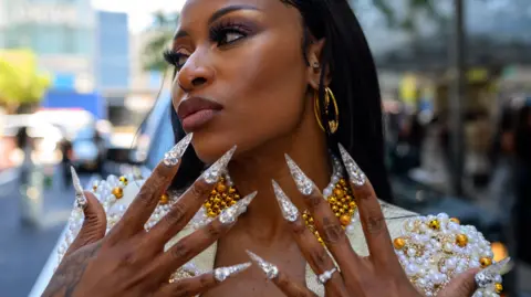 ALEXI ROSENFELD /GETTY IMAGES  DJ Zinhle wearing Sam Mosala from South Africa poses outside Pat Bo during New York Fashion Week.