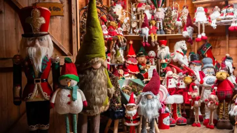 A selection of dozens of Christmas toys on display including santas, snowmen and elves 