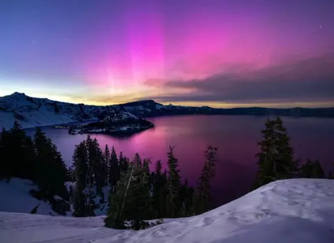 Robin Loznak/ZUMA/REX/Shutterstock The Northern Lights (aurora borealis), glowing on the horizon, over Crater Lake at Crater Lake National Park in Oregon,  11 May 2024