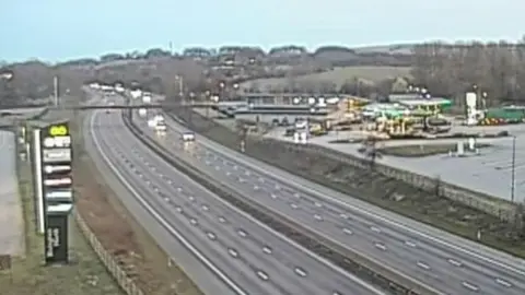 The northbound M61 is free of cars with a handful of cars, with their headlights on, travelling southbound which is still open