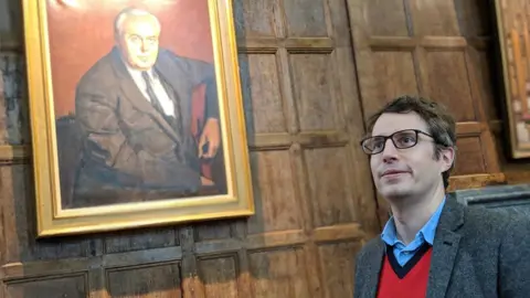 BBC James Tilley and a portrait of Harold Wilson