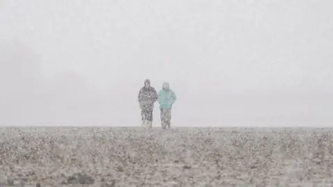 Ian Forsyth/Getty Images A couple walk along Redcar beach