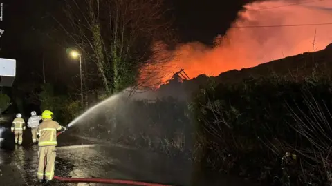 Andrew Beckett A firefighter tackles flames at the scene.