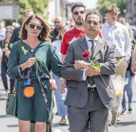 Danny Lawson/PA Wire Emma Webber and Dr Sanjoy Kumar walk arm in arm during a memorial