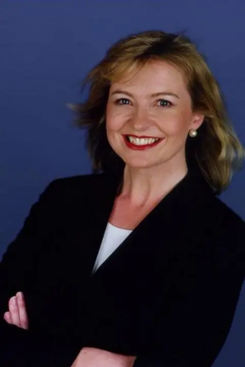 Carol Kirkwood in 2002, smiling with her arms crossed.