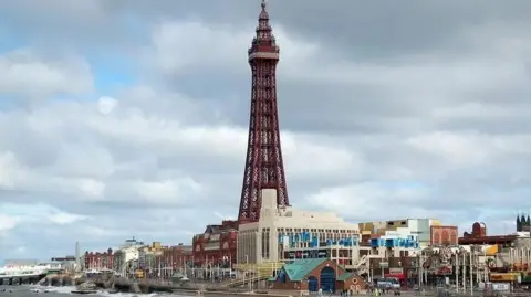 Blackpool Promenade showing part of the sea and Blackpool Tower (centre) and North Pier to the left