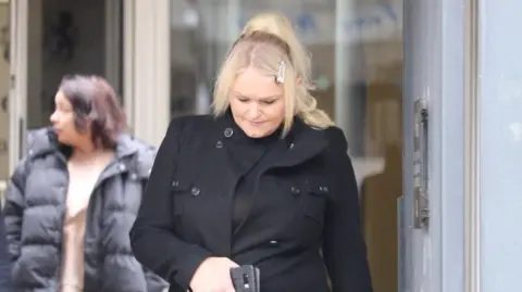 Stuart Woodward/BBC Hollie Dance leaves Southend Crown Court in a black coat