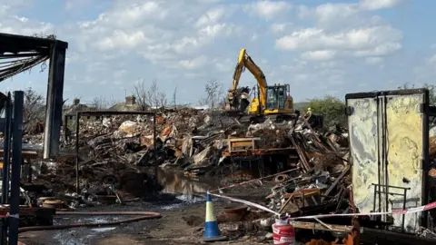 Nottinghamshire Fire and Rescue Service Nottinghamshire Fire and Rescue Service remain at the scene on Wednesday 22 April 2026 at Hathernware Industrial Estate, in Sutton Bonington, after a fire started on 15 April 2026.
