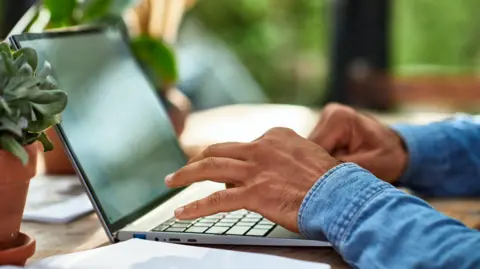 Close up of man's hands typing on laptop keyboard