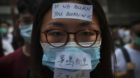 EPA Masked protesters march in the street as they take part in a rally held to show opposition to an anti-mask law meant to deter anti-government protesters,