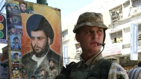 AFP British soldier next to portrait of Moqtada al-Sadr in Basra, 2005