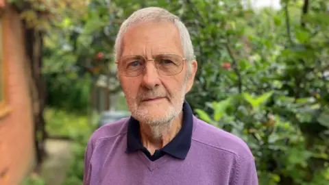 Cleobury Mortimer resident and son of veteran Victor Todd standing in his back garden wearing a polo shirt and purple jumper