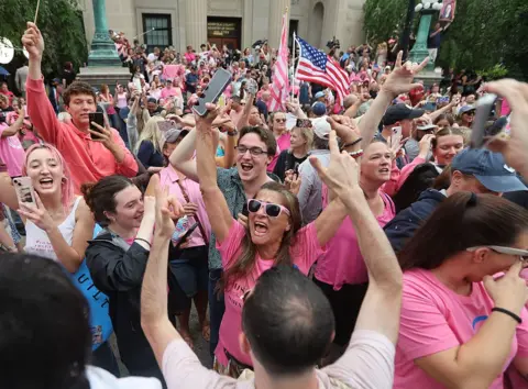 Getty Images People in pink crowd and cheer