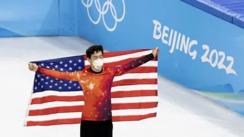 EPA US gold medallist Nathan Chen holds the American flag while celebrating his men's figure skating win on Thursday