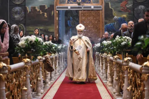 Getty Images Seorang pendeta memimpin perayaan Malam Natal Ortodoks di Gereja Ortodoks Koptik Malaikat Tertinggi Michael di Kairo pada 6 Januari 2025. 