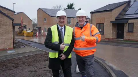 City of Wolverhampton Council Councillor Steve Evans and Gavin Ward, from developer Morro Partnerships at the development where the homes are close to completion. They are built in a light brown colour brick with black roofs and solar panels
