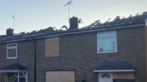 Luke Deal/BBC Closer view of the damage to the roof of the homes from the front of the house. It has mostly burnt away.