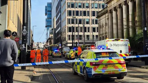 A bystander watches near a police cordon strapped near the art gallery and other modern office and apartment blocks