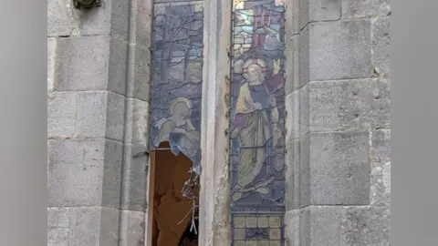 A smashed stained glass window at St Mary the Virgin Church in Coleorton, Leicestershire.