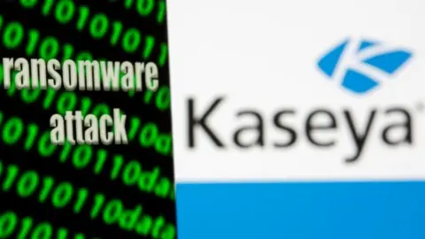 Reuters A smartphone with the words "Ransomware attack" and binary code is seen in front of the Kaseya logo in this illustration taken