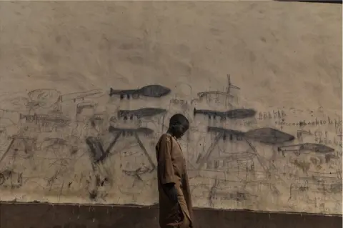 Marco Gualazzini / Contrasto A child stands in front of wall covered in drawings