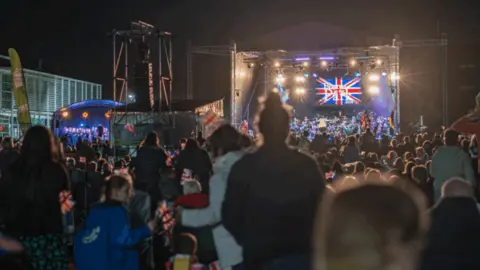 Aylesbury Town Council crowd in semi darkness watching a stage