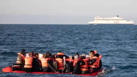 Getty Images Refugees/asylum seekers in life jackets on boat in the Channel, P&O ferry in the background