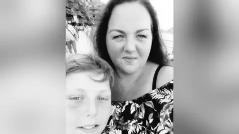 Marrissa Mullans A black-and-white photograph of a mum and son, who both have dark hair.